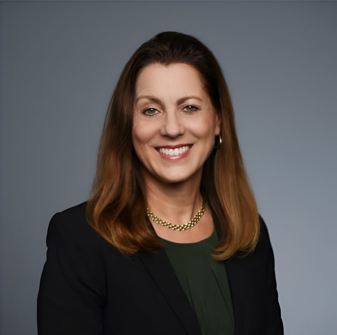 Professional woman smiling in a studio portrait.