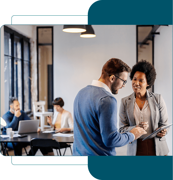 Two colleagues collaborating over a document in a modern office.