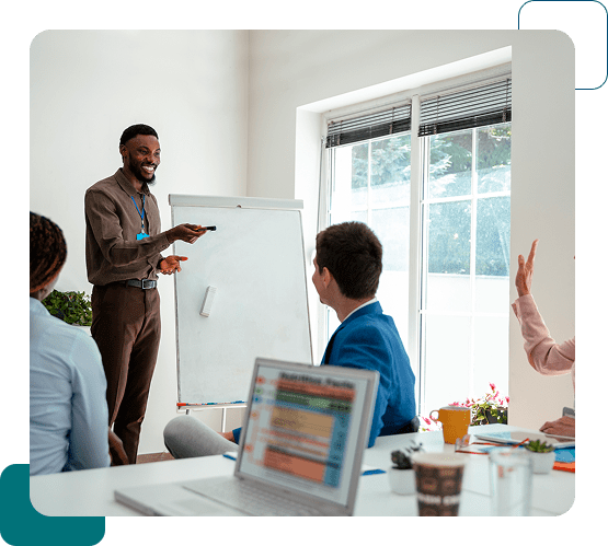 Man presenting to colleagues in a bright meeting room.