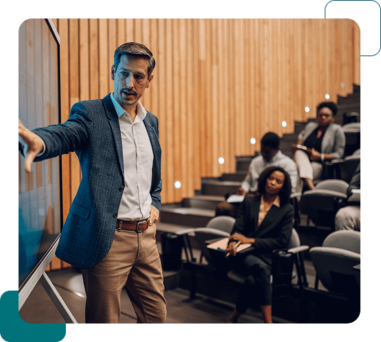 A man in a blue blazer giving a lecture to an attentive audience in a modern classroom.