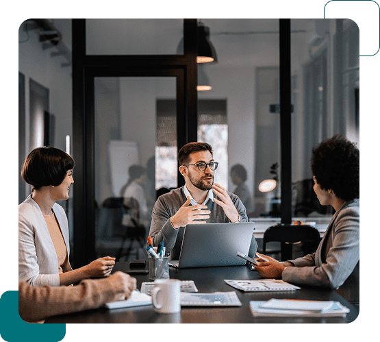 Business meeting with colleagues discussing ideas around a laptop.