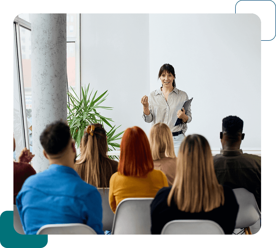 Woman giving a presentation to an attentive audience in a modern setting.