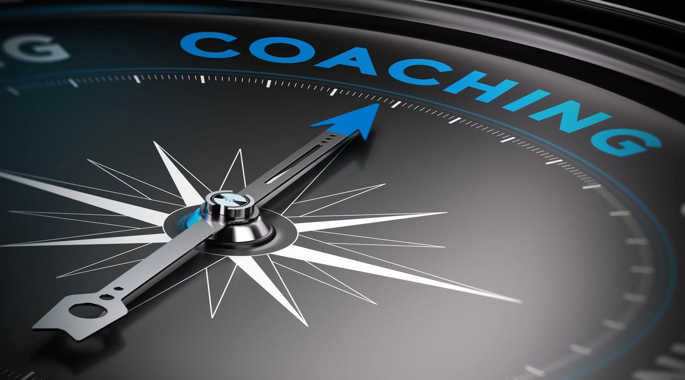Compass needle pointing to the word 'COACHING'.