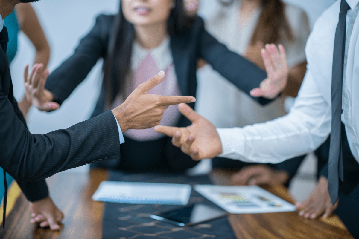 People in a business meeting making hand gestures.
